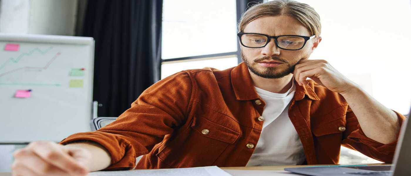 Man Looking At Paperwork In His Office Rental